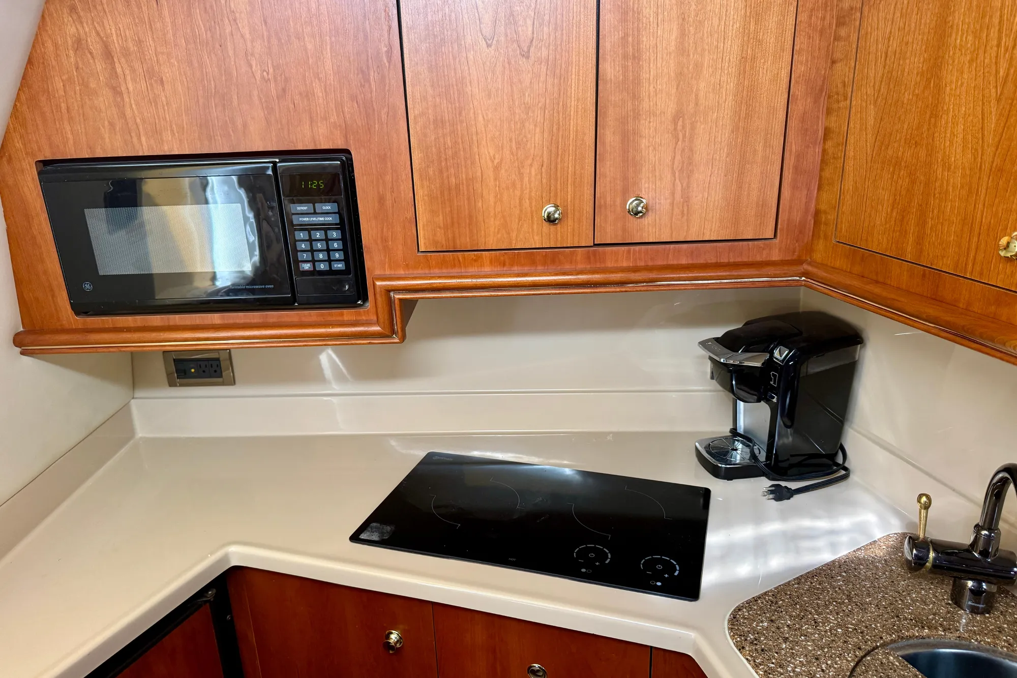 2001 Cruisers Yachts 3470 Express kitchen with microwave, stovetop, and coffee maker.