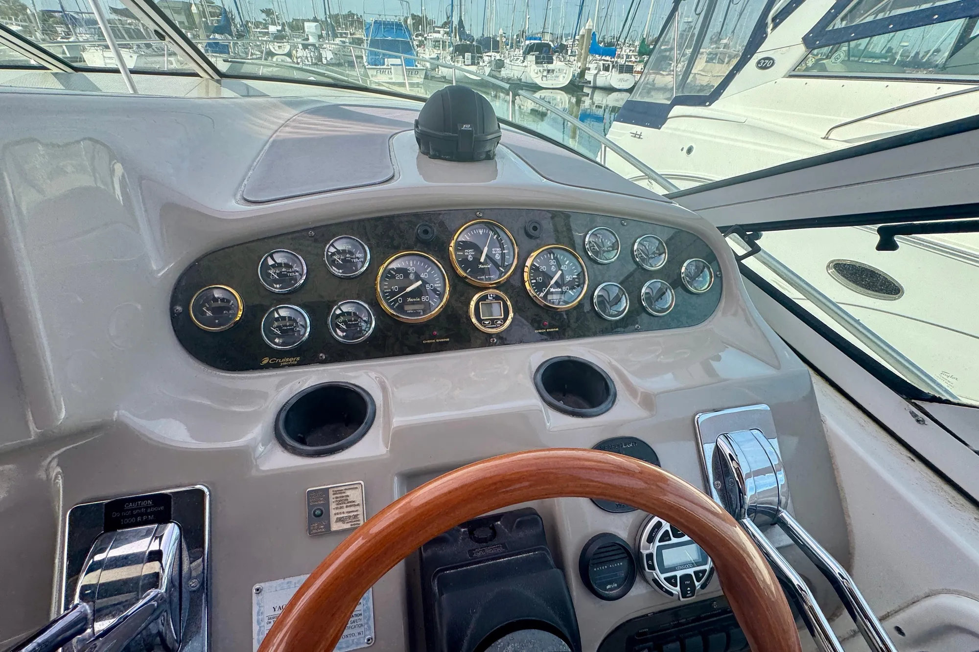 2001 Cruisers Yachts 3470 Express helm with gauges and wooden steering wheel.
