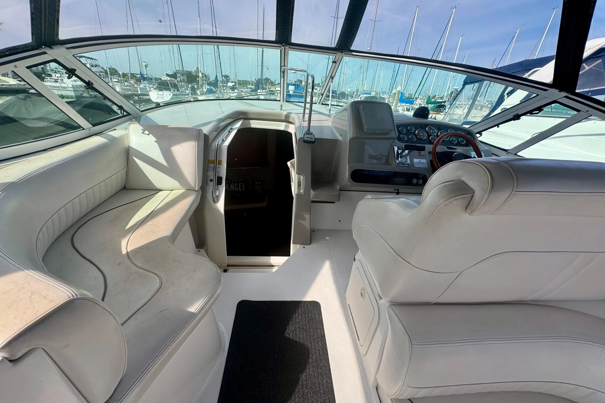 2001 Cruisers Yachts 3470 Express cockpit with white seating and helm, docked at marina.