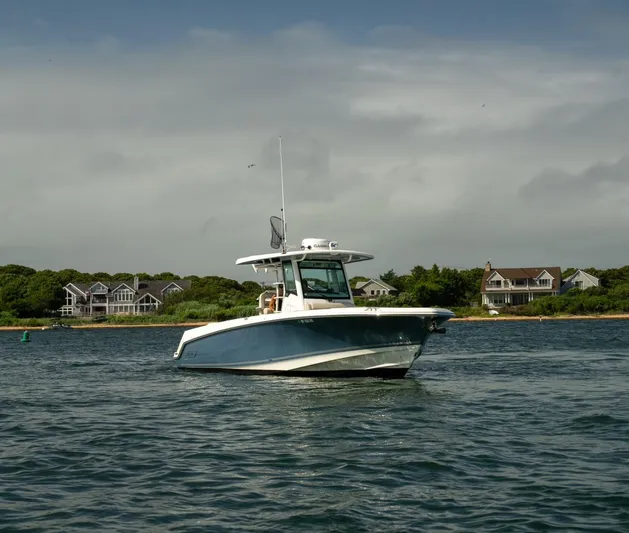 Just Wednesdays Yacht Photos Pics 2022 Boston Whaler 330 Outrage boat on water near coastal homes.