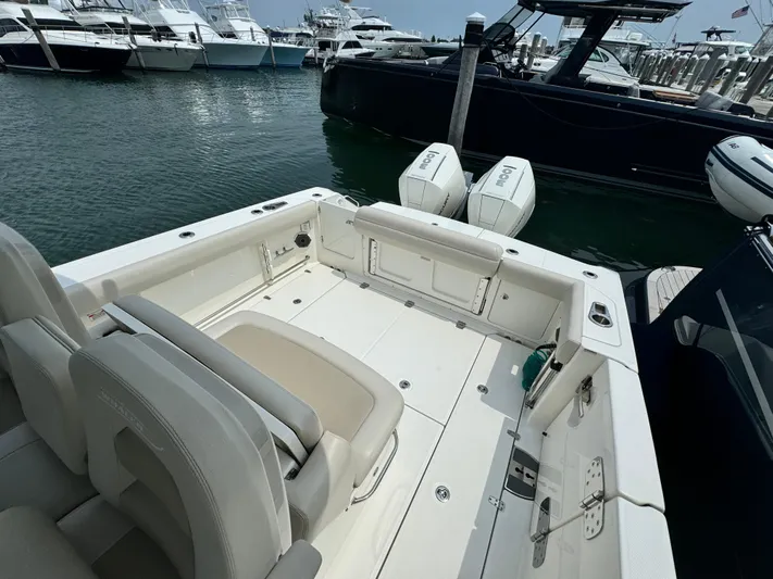 Just Wednesdays Yacht Photos Pics 2022 Boston Whaler 330 Outrage boat docked, featuring spacious deck and twin engines.