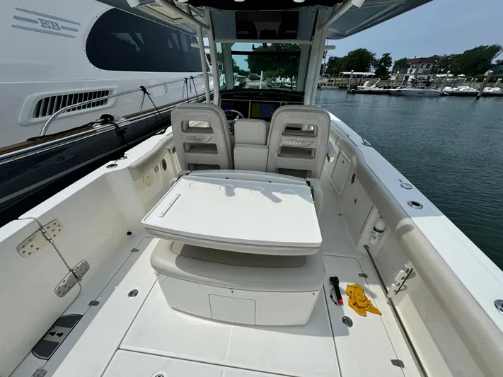 Just Wednesdays Yacht Photos Pics 2022 Boston Whaler 330 Outrage boat interior with seating and table, docked at marina.