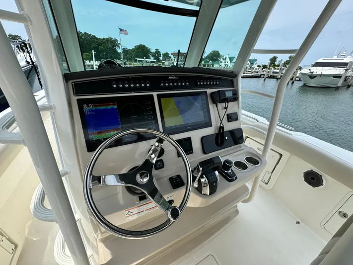 Just Wednesdays Yacht Photos Pics 2022 Boston Whaler 330 Outrage helm with advanced navigation system and steering wheel, docked at marina.