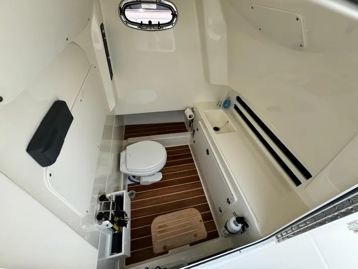 Just Wednesdays Yacht Photos Pics 2022 Boston Whaler 330 Outrage cabin interior with toilet and wooden flooring.