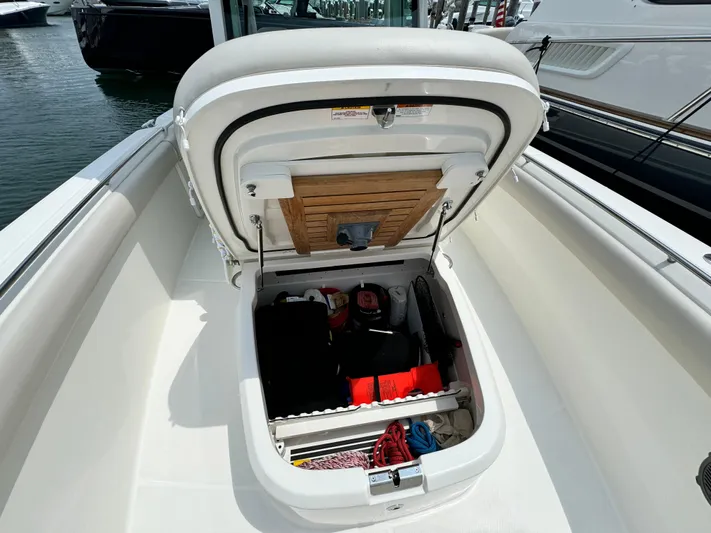 Just Wednesdays Yacht Photos Pics 2022 Boston Whaler 330 Outrage storage compartment open, revealing organized interior with boating essentials.