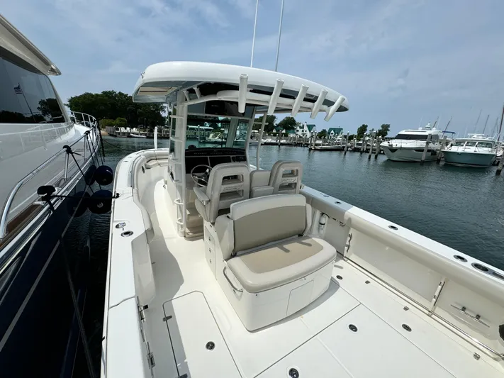 Just Wednesdays Yacht Photos Pics 2022 Boston Whaler 330 Outrage boat docked at marina, featuring spacious seating and sleek design.