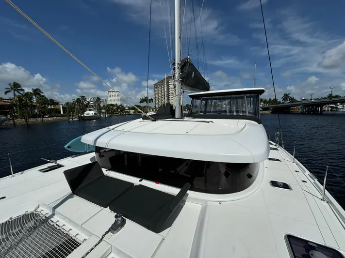  Yacht Photos Pics 2023 Lagoon 42 catamaran docked in a marina, featuring a sleek design and spacious deck.