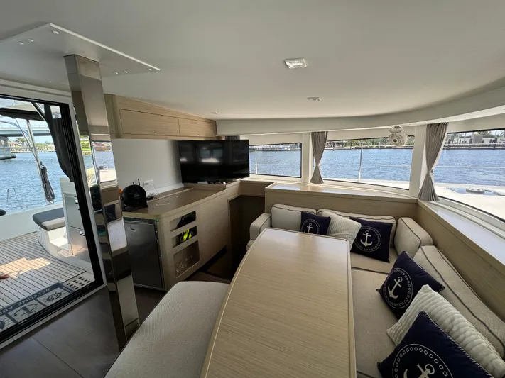  Yacht Photos Pics Interior of 2023 Lagoon 42 catamaran with modern seating, TV, and nautical decor.