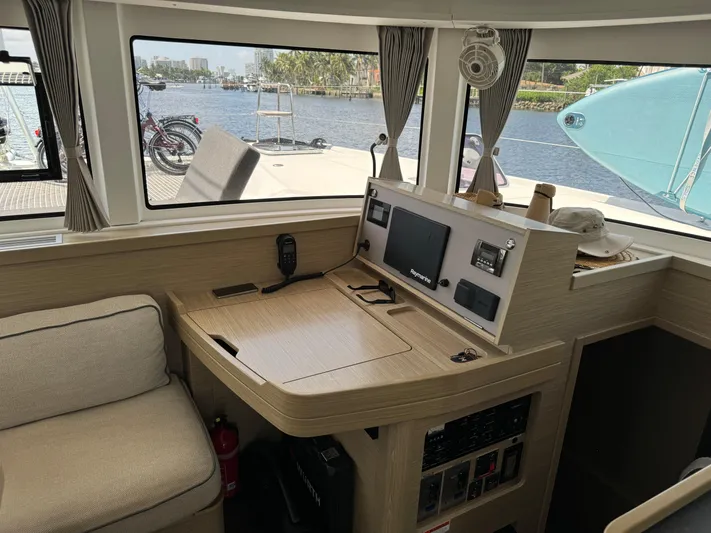  Yacht Photos Pics 2023 Lagoon 42 yacht interior with navigation station and waterfront view.