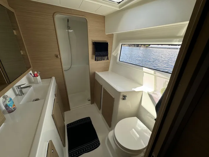  Yacht Photos Pics Modern bathroom in 2023 Lagoon 42 yacht with shower, sink, and window view.