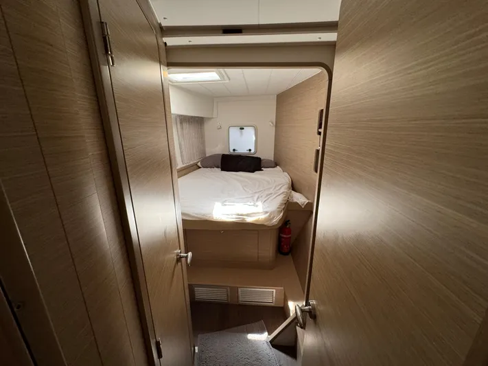  Yacht Photos Pics 2023 Lagoon 42 yacht cabin with cozy bed and wooden interior.