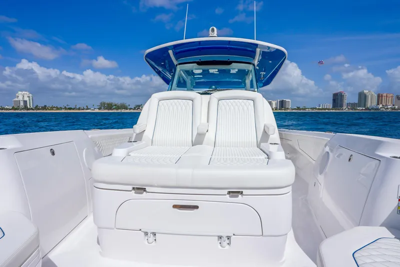  Yacht Photos Pics 2024 Intrepid 427 Nomad SE boat interior with white seating, ocean view, and city skyline.