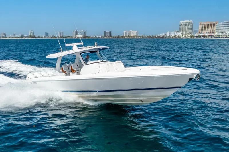  Yacht Photos Pics 2024 Intrepid 427 Nomad SE cruising on blue ocean near city skyline.