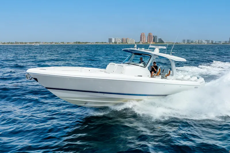  Yacht Photos Pics 2024 Intrepid 427 Nomad SE cruising on open water, city skyline in background.