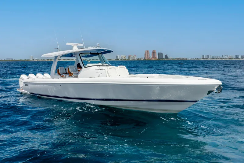  Yacht Photos Pics 2024 Intrepid 427 Nomad SE boat cruising on open water, city skyline in background.