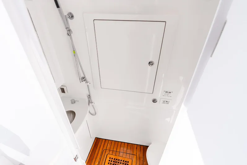  Yacht Photos Pics 2024 Intrepid 427 Nomad SE boat bathroom with shower, sink, and wooden floor.