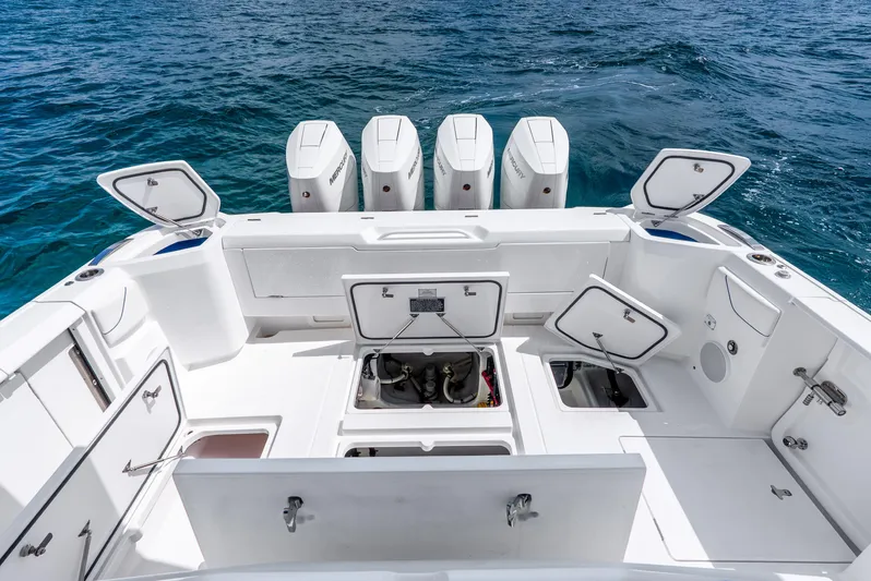  Yacht Photos Pics 2024 Intrepid 427 Nomad SE boat deck with open storage compartments and four outboard engines.