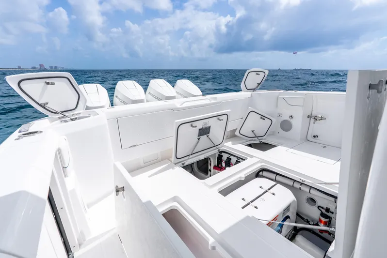  Yacht Photos Pics 2024 Intrepid 427 Nomad SE boat with open storage compartments, ocean backdrop, and clear sky.