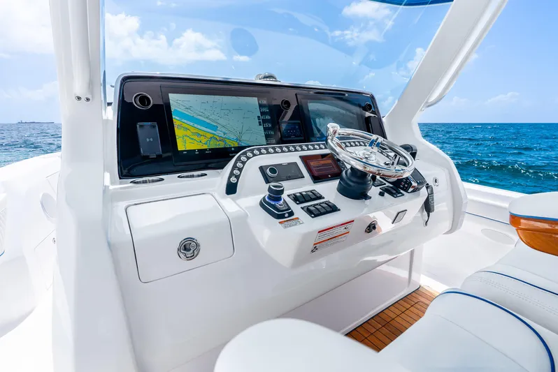  Yacht Photos Pics 2024 Intrepid 427 Nomad SE boat dashboard with navigation screen, steering wheel, and ocean view.