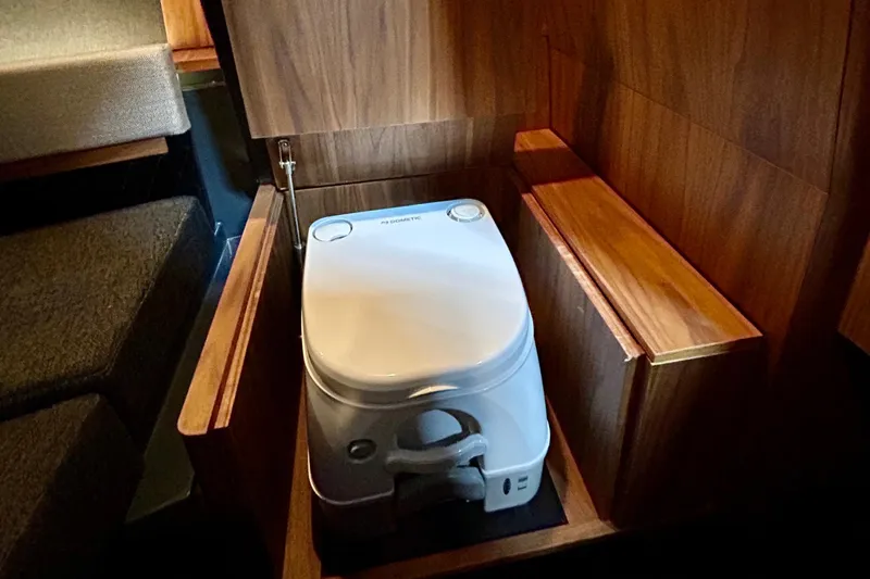  Yacht Photos Pics Compact marine toilet in 2026 Flynt Yachts Centura 32, featuring sleek wooden cabinetry.