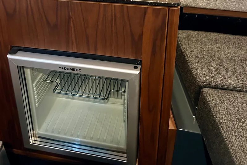  Yacht Photos Pics Dometic fridge in Flynt Yachts Centura 32, 2026 model, with wooden cabinetry and seating.