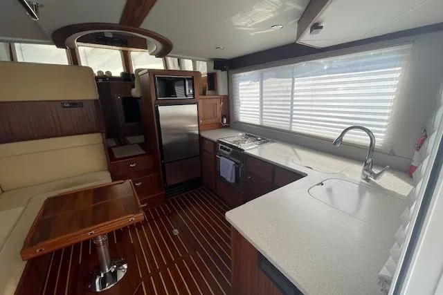  Yacht Photos Pics Interior of 2018 American Tug 365, featuring modern kitchen and dining area with wood accents.