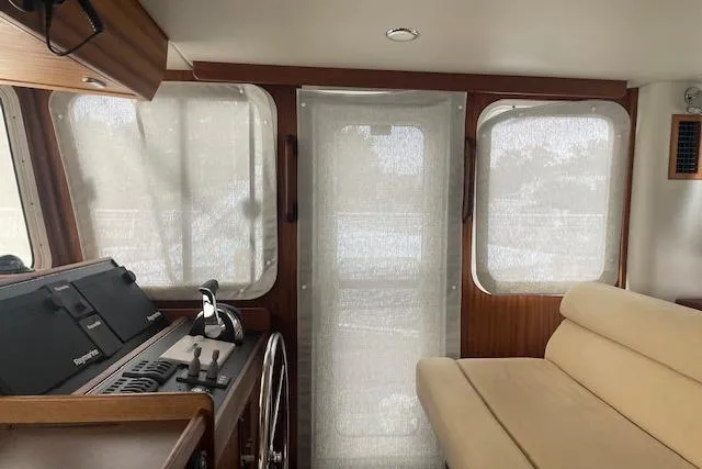  Yacht Photos Pics Interior of 2018 American Tug 365 with helm, beige seating, and large windows.