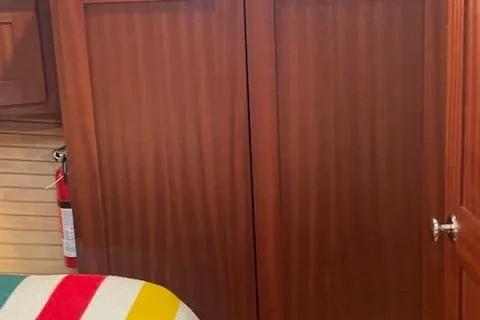  Yacht Photos Pics Interior of 2018 American Tug 365 with wooden cabinetry and colorful bedding.