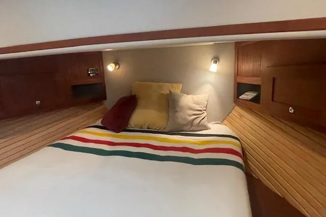  Yacht Photos Pics Cozy cabin interior of 2018 American Tug 365 with striped bedding and wooden accents.