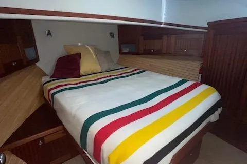  Yacht Photos Pics Cozy cabin interior of 2018 American Tug 365 with striped bedding and wooden accents.