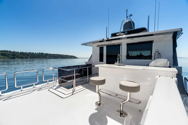 V68-612 / Now Available Yacht Photos Pics Luxury Horizon V68 yacht deck with bar stools, overlooking serene waters, 2025 model.