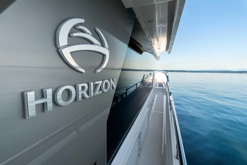 V68-612 / Now Available Yacht Photos Pics 2025 Horizon V68 yacht on serene water, showcasing sleek design and branding.