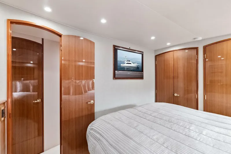 Cap'n Hook Yacht Photos Pics Luxurious interior of 2006 Viking 68 Enclosed Bridge yacht bedroom with wood doors.