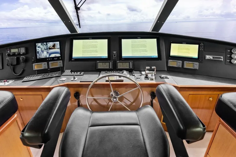 Cap'n Hook Yacht Photos Pics Control panel of 2006 Viking 68 Enclosed Bridge yacht with multiple screens and steering wheel.