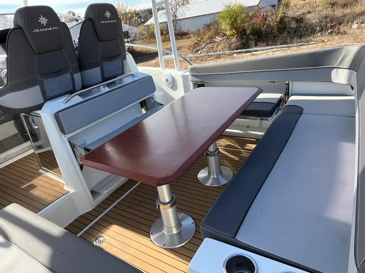  Yacht Photos Pics 2019 Jeanneau Leader 9.0 WA boat interior with seating and wooden table.