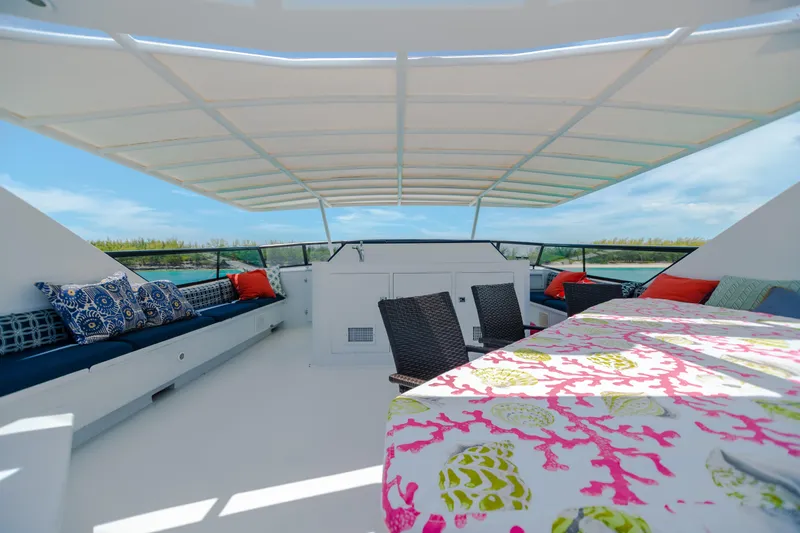 Island Time Yacht Photos Pics Spacious deck of 1991 Broward Motor Yacht with colorful seating and ocean view.