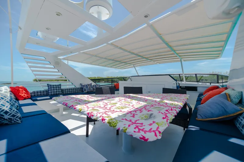 Island Time Yacht Photos Pics Spacious deck of 1991 Broward Motor Yacht with colorful seating and table.