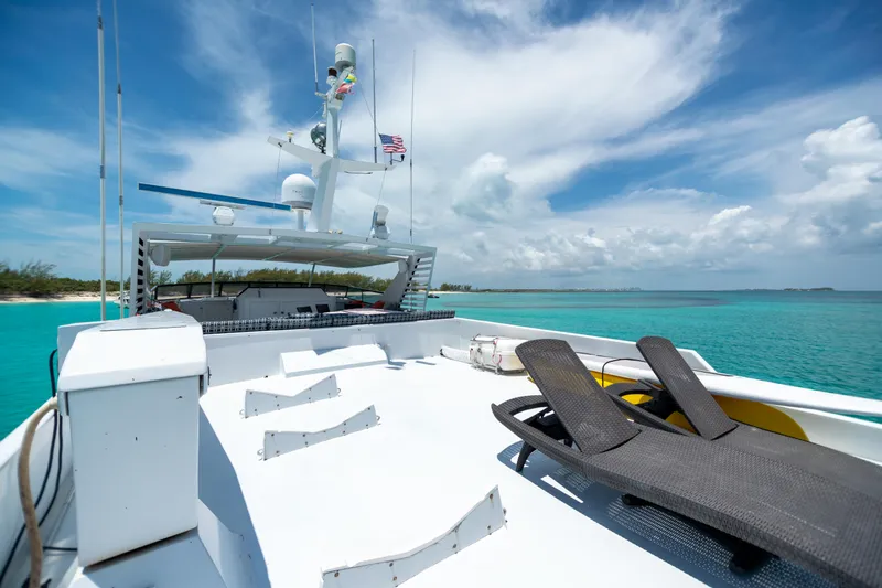 Island Time Yacht Photos Pics 1991 Broward Motor Yacht deck with lounge chairs, clear turquoise water, and blue sky.