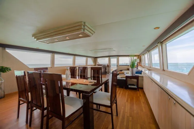 Island Time Yacht Photos Pics Luxurious dining area inside a 1991 Broward Motor Yacht with panoramic ocean views.