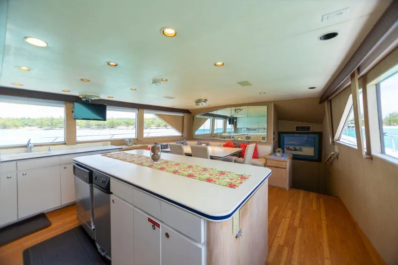 Island Time Yacht Photos Pics Spacious interior of a 1991 Broward Motor Yacht with modern kitchen and panoramic windows.