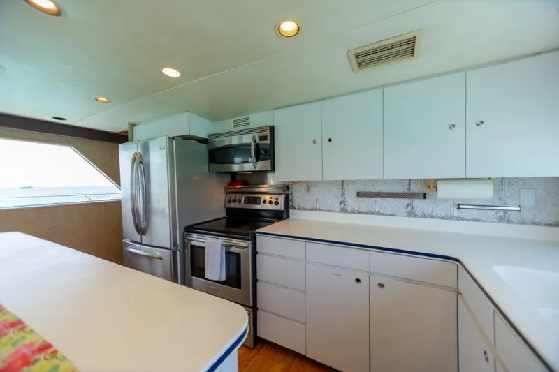 Island Time Yacht Photos Pics Modern kitchen in a 1991 Broward Motor Yacht with stainless steel appliances.