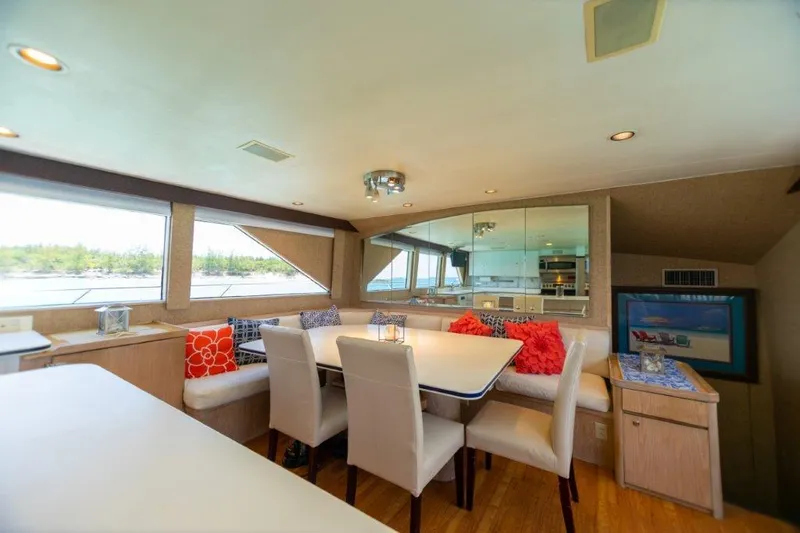 Island Time Yacht Photos Pics Luxurious dining area inside a 1991 Broward Motor Yacht with scenic window views.
