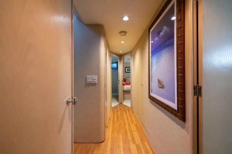 Island Time Yacht Photos Pics Hallway interior of a 1991 Broward Motor Yacht with wooden flooring and wall art.