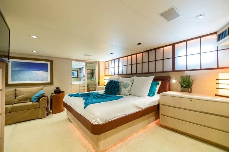 Island Time Yacht Photos Pics Luxurious bedroom interior of 1991 Broward Motor Yacht with modern decor and ambient lighting.