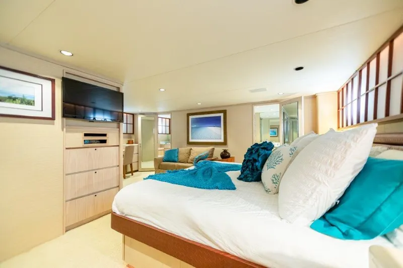 Island Time Yacht Photos Pics Luxurious bedroom interior of 1991 Broward Motor Yacht with modern decor and cozy seating area.
