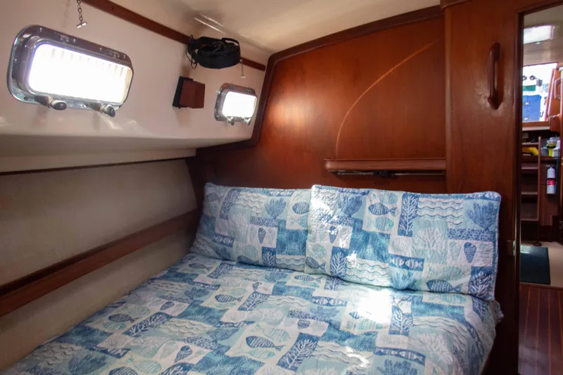 Blue Skies Yacht Photos Pics Cozy cabin interior of 1995 Island Packet 40 sailboat with nautical-themed bedding.