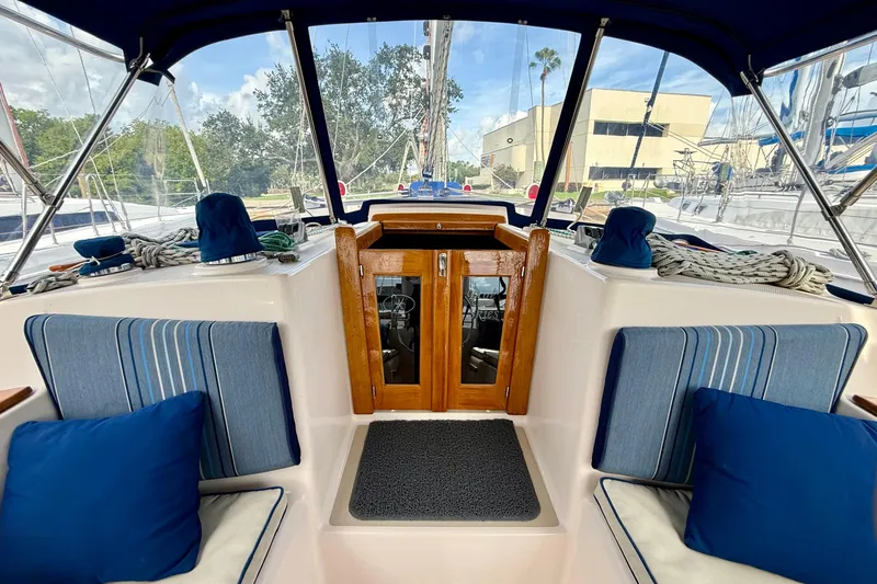 Blue Skies Yacht Photos Pics 1995 Island Packet 40 sailboat cockpit with blue cushions and wooden doors.