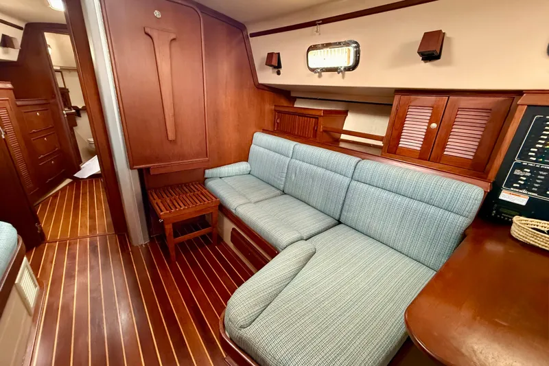 Blue Skies Yacht Photos Pics Interior of 1995 Island Packet 40 sailboat with wooden finishes and blue seating.