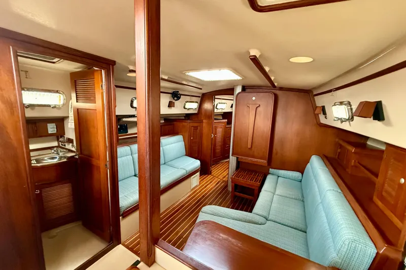 Blue Skies Yacht Photos Pics Interior of 1995 Island Packet 40 sailboat with wood finish and blue seating.