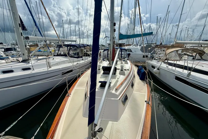 Blue Skies Yacht Photos Pics 1995 Island Packet 40 sailboat docked among other yachts under cloudy skies.